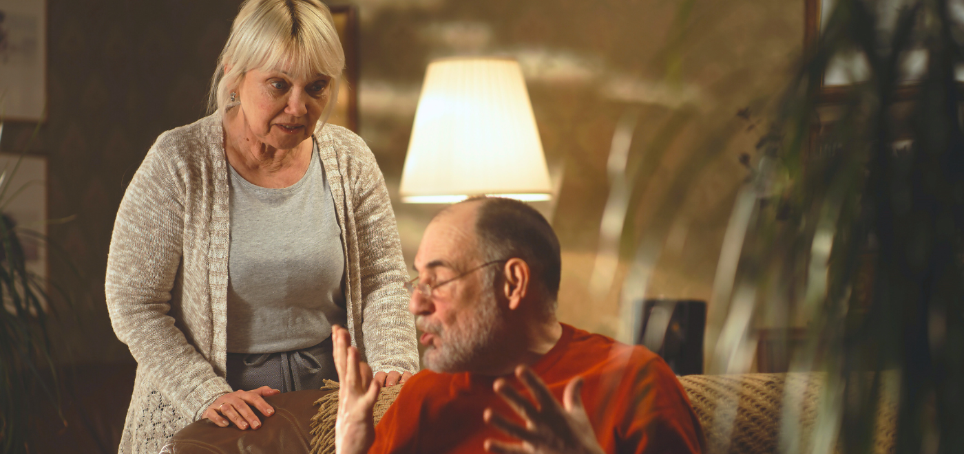 Female caregiver and male care recipient during a challenging moment at home.