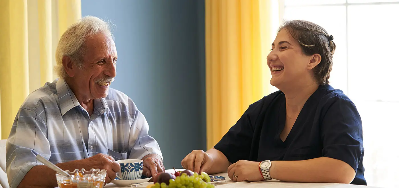 Family Caregiver enjoying meal with his loved one Family Caregiver enjoying meal with his loved one